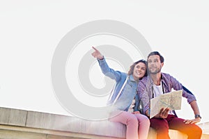 Attractive man holding map while sitting and talking to his girlfriend