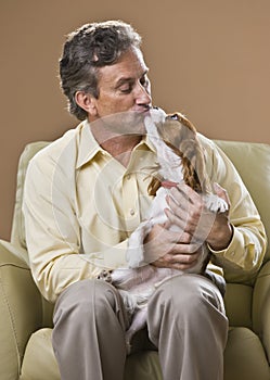 Attractive man kissing dog.