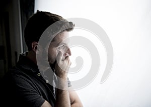 Attractive man leaning on window suffering emotional crisis and depression