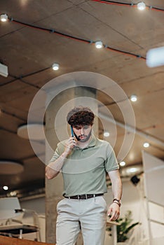 Attractive man leaving the meeting space for a private phone call