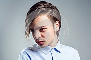 Attractive man with long fringe hairstyle on his eyes, looking away with mysterious look.