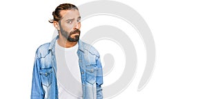 Attractive man with long hair and beard wearing casual denim jacket skeptic and nervous, frowning upset because of problem