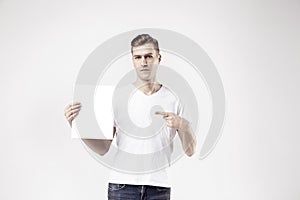 attractive man model is showing white empty space paper A4 for advert