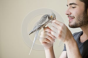 Attractive man playing with his parrot