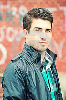 Attractive man posing outdoor over graffiti wall