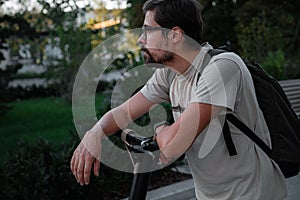 Attractive man riding a kick scooter at cityscape background