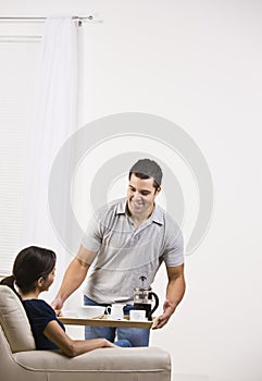 Attractive man serving a tray of food to a woman.