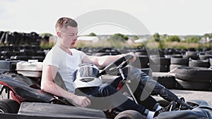 Attractive man sititng in a gocart on the track