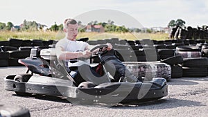 Attractive man sititng in a gocart on the track