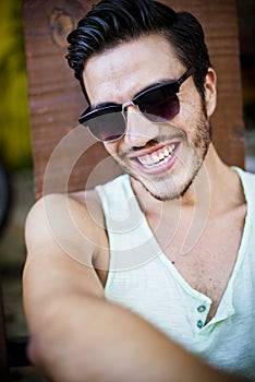 Attractive man in summer sitting outdoors