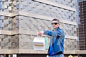 Attractive man with sunglasses and a suit case photo