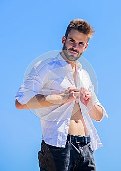 Attractive man taking off shirt. Confident in his appealing. Bearded guy business style. Handsome man fashion model