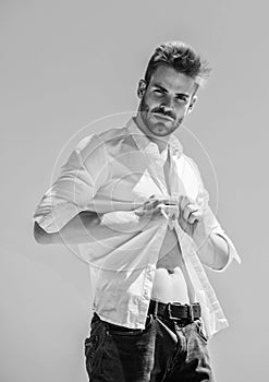 Attractive man taking off shirt. Confident in his appealing. Bearded guy business style. Handsome man fashion model