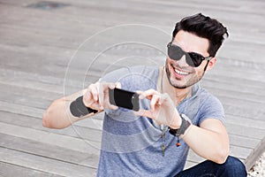 Attractive man taking photos with a smartphone