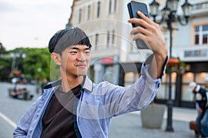 Attractive man taking selfie on european city square