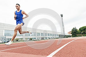 Attractive man Track Athlete Running On Track.