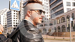 An attractive man wearing black leather jacket with dark sunglasses