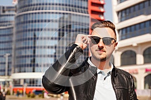 An attractive man wearing black leather jacket with dark sunglasses