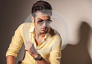 Attractive man wearing sunglasses and yellow shirt