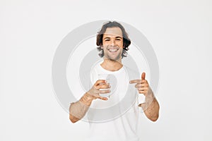 Attractive man in a white T-shirt glass of water  background