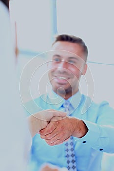 Attractive man and woman business team shaking hands at office building.