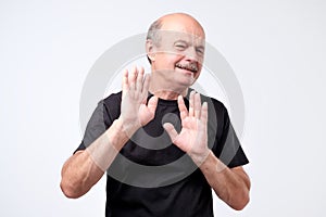 Attractive mature bald man showing refusal gesture