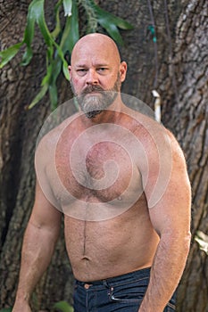 Attractive mature man with no shirt posing outdoors