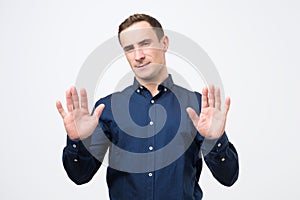 Attractive mature man shows refusal gesture, does not want to participate in meeting