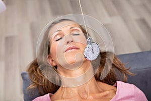 Woman Being Hypnotized While Lying On Sofa