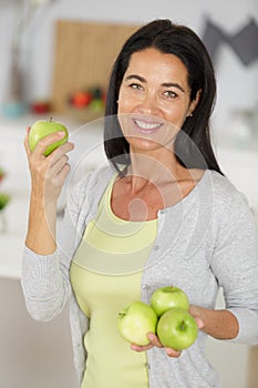 Attractive mature woman holding four apples