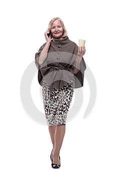 attractive mature woman with smartphone and coffee to take away.
