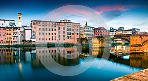 Attractive medieval arched St Trinity bridge Ponte Santa Trinita over Arno river. Colorful spring sunset in Florence, Italy, Eur