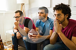 Attractive men feeling anxious while watching their favorite football team