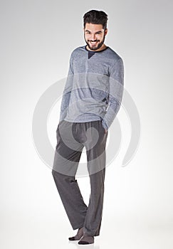 Attractive men in pyjamas smiling isolated on grey