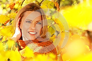 Attractive middle age woman in front of autumn leaves