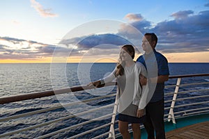 Attractive middle-aged couple enjoying the sunset view from the deck of a cruise ship