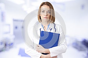 Attractive middle aged female doctor standing in doctor`s room photo