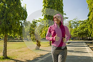 Attractive middle aged lady running happy at city park . beautiful and sporty woman on her 40s exercising doing jogging workout on