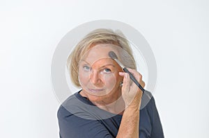 Attractive middle-aged woman applying makeup