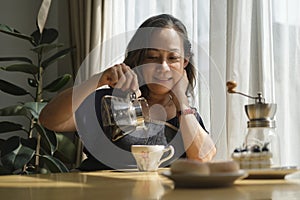 Attractive middle aged woman drinks coffee in the kitchen at home. Retirement, Healthy seniors lifestyle