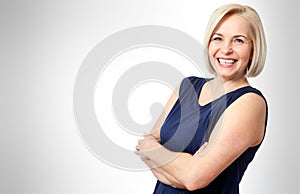 Attractive middle aged woman with folded arms on white background