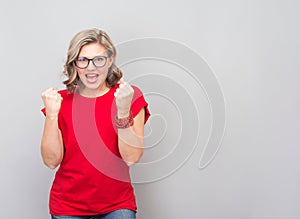 Attractive middle aged woman happy and excited doing winner gesture with arms raised, smiling and screaming for success.