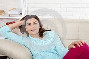 Attractive middle aged woman looking in camera relaxing at home. The beautiful face close up.