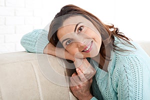 Attractive middle aged woman looking in camera relaxing at home. The beautiful face close up.