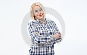 Attractive middle aged woman in a plaid shirt with folded arms isolated on white background