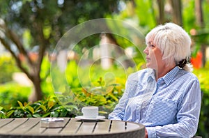 Attractive middle-aged woman relaxing on an outdoor patio