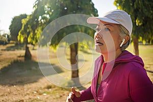 Attractive middle aged woman running happy at city park . beautiful and sporty lady on her 40s exercising doing jogging workout on