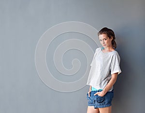 Attractive middle aged woman standing against gray background