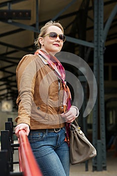 Attractive middle aged woman with sunglasses and bag