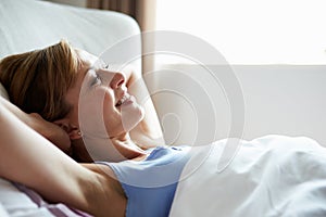 Attractive Middle Aged Woman Waking Up In Bed photo